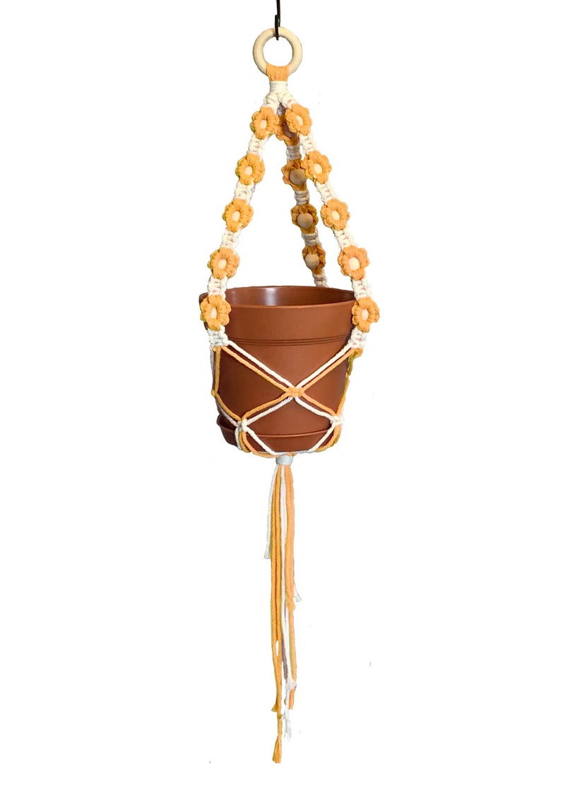 A plant hanger with beautiful floral details that come in a variety of colors to choose from.