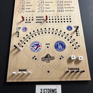 May include: Wooden baseball game board with a baseball field design, team logos, dice, and pegs. The board includes game outcome indicators and a "World Series 2025" inscription. The board is made of light-coloured wood.