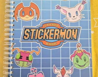 Puede incluir: Un libro de pegatinas con encuadernación en espiral y una cubierta azul claro con un patrón de cuadrícula blanca. La cubierta muestra el texto STICKERMON BOOK en una fuente naranja y azul, rodeado por ocho ilustraciones de cabezas de personajes.