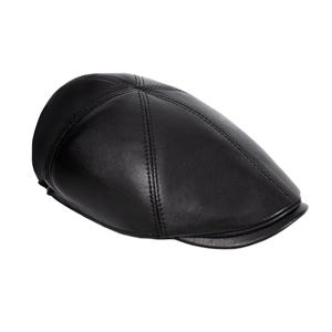 Könnte beinhalten: Eine schwarze Leder-Newsboy-Mütze mit einem gesteppten Design.