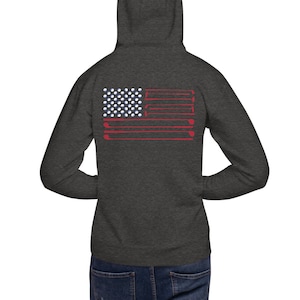 May include: A dark heather grey hoodie with a red, white, and blue American flag design on the back. The flag is made up of golf balls and golf clubs.
