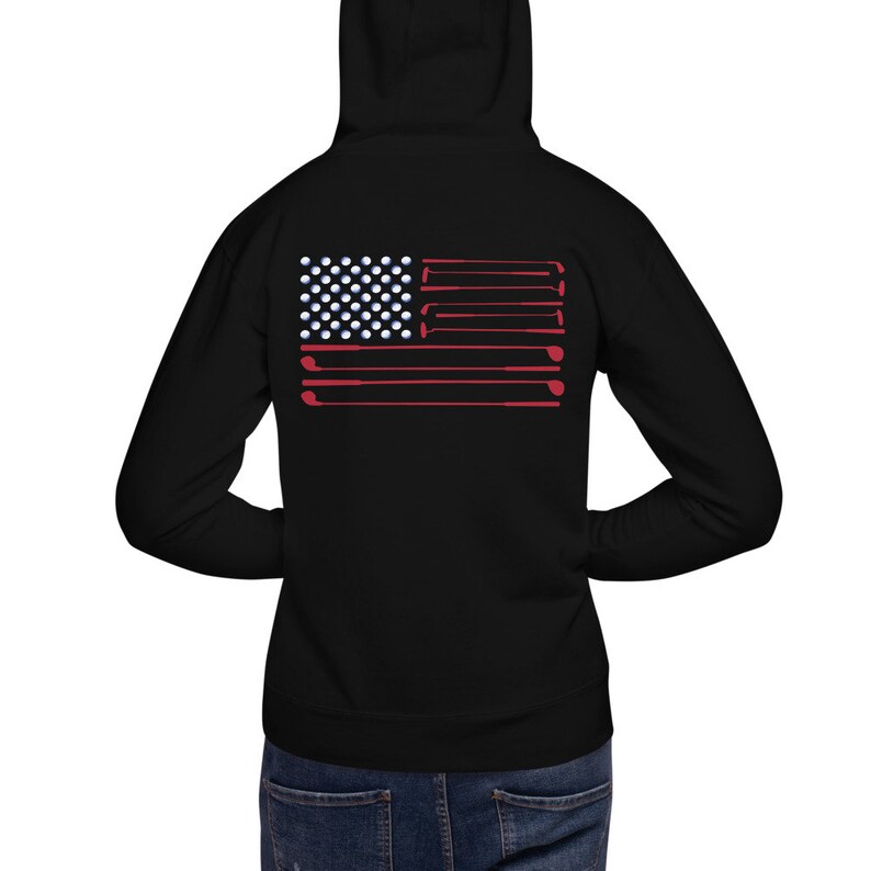 May include: Black hooded sweatshirt with a red, white, and blue American flag design made of golf balls and golf clubs.
