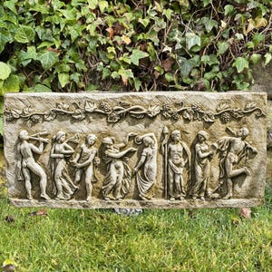 May include: A stone relief sculpture depicting a group of figures in a procession. The figures are carved in a classical style and are wearing flowing robes. The sculpture is set against a background of vines and grapes.