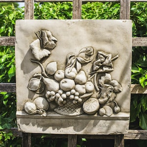 May include: A white stone relief sculpture of a basket of fruit with grapes, apples, and pears. The sculpture is labelled with the Latin names for the fruits: Pyrus & Cydonius, Prunus Vitis, and Ficus Malus.