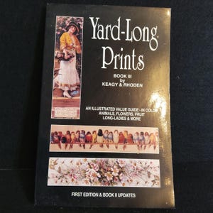 May include: A vintage book titled "Yard-Long Prints" with a black cover. The cover features an illustration of a woman and various images of birds and flowers. The book is a guide to illustrated value, including animals, flowers, fruit, and more.