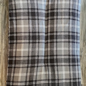 May include: A gray and black plaid dog bed cushion. The cushion is made of a soft, comfortable fabric and has a rectangular shape.