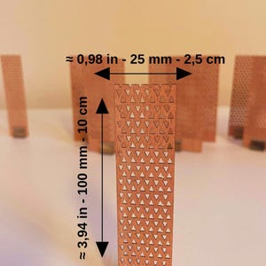 May include: A rectangular wooden slat featuring a repeating pattern of small triangular cutouts. The slat measures approximately 0.98 inches in width and 3.94 inches in height. It is held upright by a small metal base at the bottom edge.