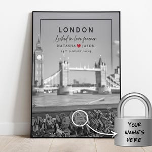 Può includere: Foto in bianco e nero del Tower Bridge a Londra con il testo "LONDON Locked in love forever. NATASHA  JASON 24th JANUARY 2025" e un cuore rosso. Un lucchetto argentato con il testo "YOUR NAME'S HERE" è in primo piano.