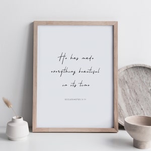 May include: A framed print with a white background and black text that reads "He has made everything beautiful in its time" with the scripture reference "Ecclesiastes 3:11" below the text.