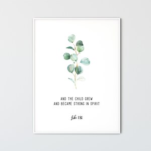 May include: A white framed print with a watercolor illustration of a green eucalyptus branch. The print features the text "And the child grew and became strong in spirit Luke 1:80".