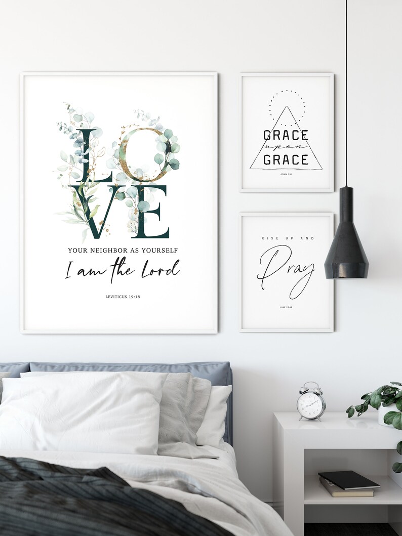 Op de afbeelding: Drie ingelijste prints met inspirerende citaten en bijbelteksten. De eerste print toont het woord "LOVE" met groen en gouden accenten, en het citaat "Heb uw naaste lief als uzelf, Ik ben de Heer, Leviticus 19:18". De tweede print toont een driehoek met de woorden "GRACE upon GRACE" en de bijbelverwijzing "Johannes 1:16". De derde print toont de woorden "Rise up and Pray" met een decoratieve zwier.