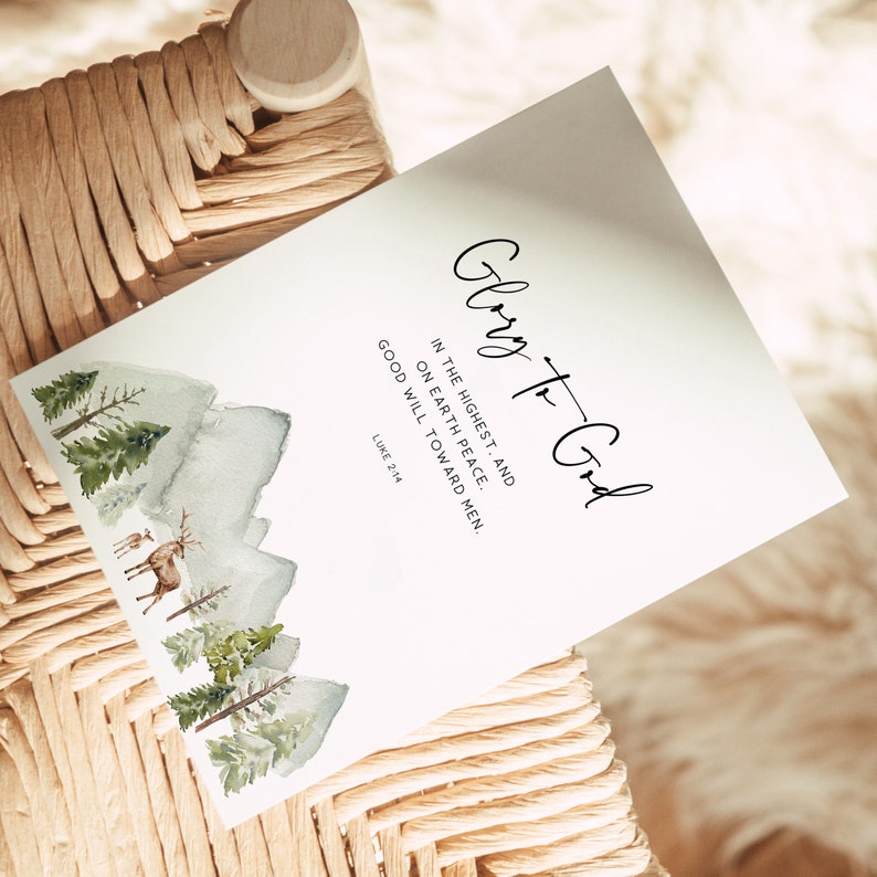 May include: A watercolor illustration of a forest scene with mountains in the background. The text "Glory to God" is written in cursive script with the Bible verse "In the highest, and on earth peace. Good will toward men. Luke 2:14" below it.