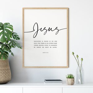 May include: A framed print with a black and white design. The print features the word "Jesus" in cursive script and a Bible verse from Acts 4:12. The verse reads: "Salvation is found in no one else, for there is no other name under heaven given to mankind by which we must be saved."