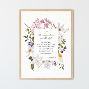 May include: A floral print with a white background and a quote from the Bible, John 11:25-26, "I am the resurrection and the life. The one who believes in me will live, even though they die: and whoever lives by believing in me will never die."