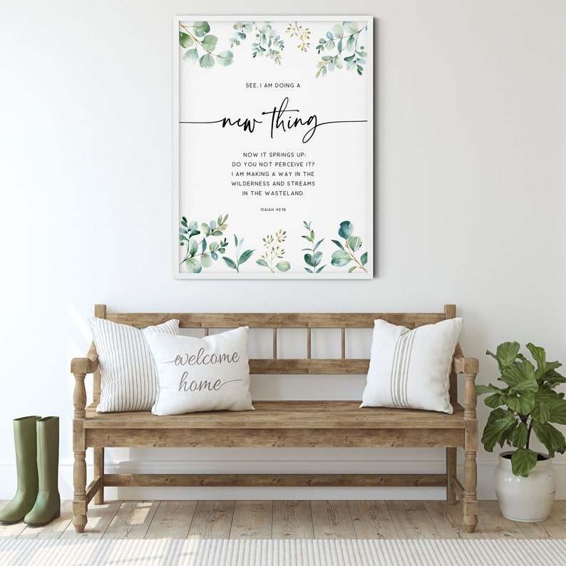 May include: A framed print with a watercolor background of green leaves and a quote from Isaiah 43:19, "See, I am doing a new thing. Now it springs up; do you not perceive it? I am making a way in the wilderness and streams in the wasteland."