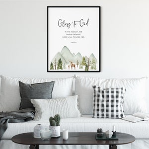 May include: A watercolor print with a mountain landscape and a deer and fawn. The print features the text "Glory to God" and a Bible verse from Luke 2:14.
