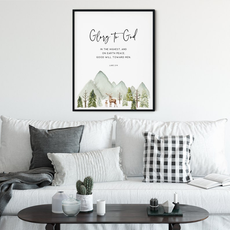 May include: A watercolor print with a mountain landscape and a deer and fawn. The print features the text "Glory to God" and a Bible verse from Luke 2:14.