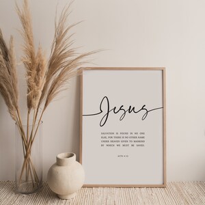 May include: A white framed print with black text that reads "Jesus" in cursive. The text below reads "Salvation is found in no one else, for there is no other name under heaven given to mankind by which we must be saved. Acts 4:12"