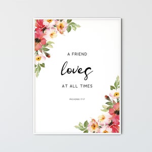 May include: A white framed print with a watercolor floral design in shades of pink, red, and green. The print features the quote "A friend loves at all times" with the scripture reference "Proverbs 17:17".