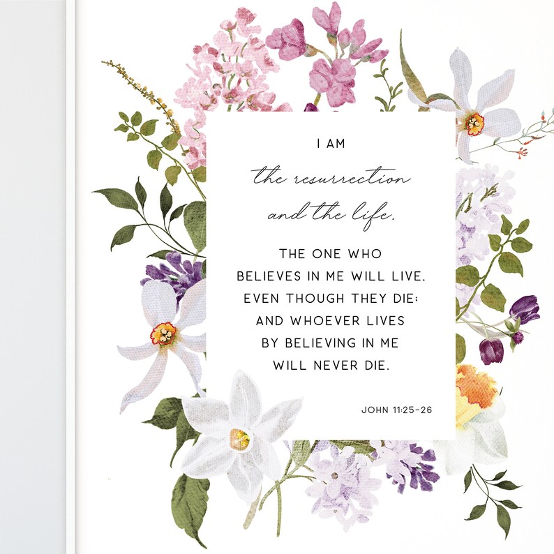 May include: A watercolour floral print with a white background and a quote from the Bible, John 11:25-26, "I am the resurrection and the life. The one who believes in me will live, even though they die: and whoever lives by believing in me will never die."