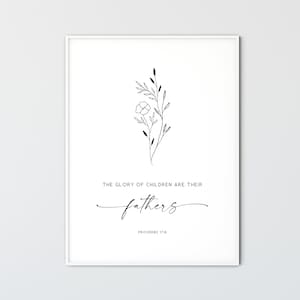 May include: A framed print with a minimalist design. The artwork features a delicate floral illustration in black ink above the quote, "THE GLORY OF CHILDREN ARE THEIR fathers" in a script font. The text "PROVERBS 17:6" is below the quote.