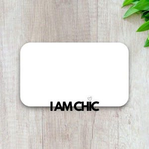 以下が含まれることがあります： 白い長方形のカードに、黒い文字で「I AM CHIC」と小さなハートのシンボルが書かれています。