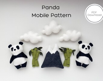 May include: A PDF pattern for a panda mobile, featuring two black and white pandas, a gray mountain, green bamboo, and white clouds.