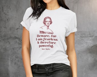 May include: White t-shirt featuring a portrait of Mary Shelley and a quote from her work in burgundy text. The quote reads, "Beware, for I am fearless & therefore powerful." A classic crew neck tee.