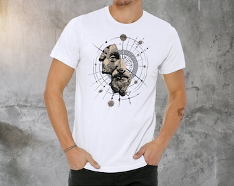 May include: White t-shirt with a graphic print of a stylized face surrounded by a circular design with geometric shapes and lines.