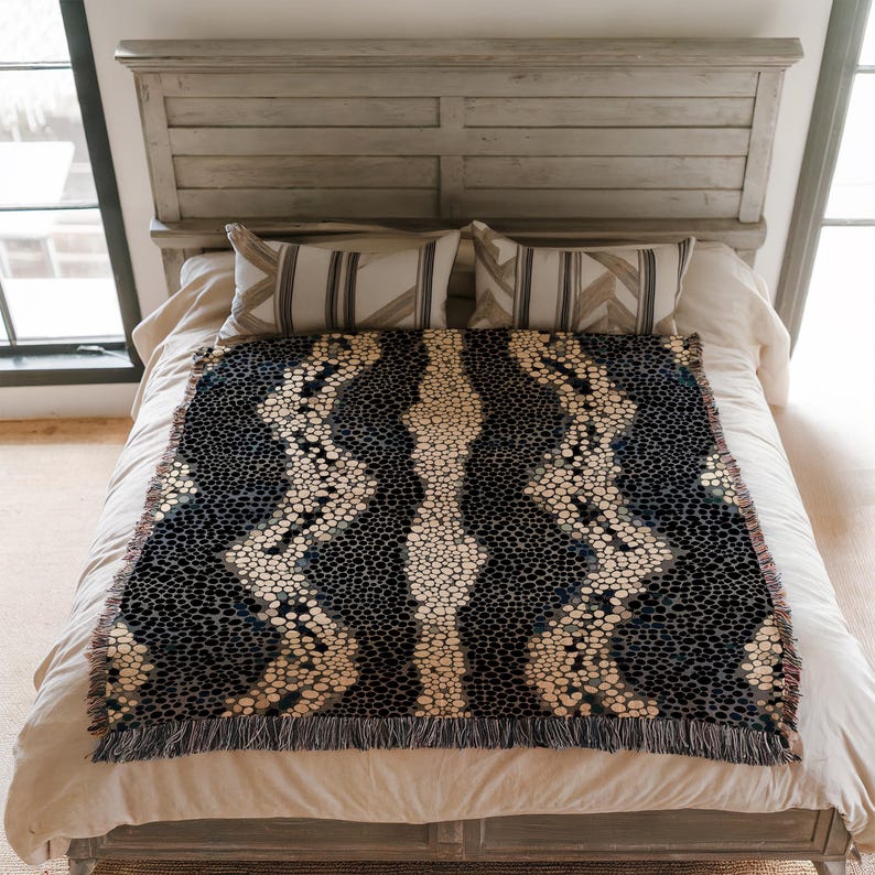 Peut inclure: Une couverture tiss&eacute;e avec un motif bleu fonc&eacute; et cr&egrave;me, avec une bande centrale cr&egrave;me et des accents pointill&eacute;s. La couverture rectangulaire a un bord &agrave; franges et est pr&eacute;sent&eacute;e sur un lit avec des oreillers.