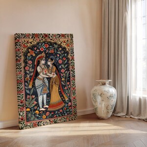 Madhubani inspired Radha Krishna canvas leaning against wall with intricate botanical folk art border