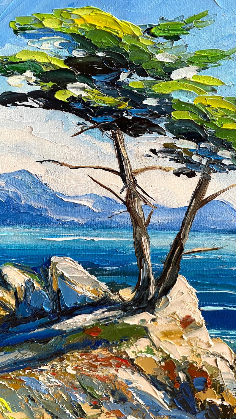 May include: Oil painting of a coastal landscape featuring a tree with green and black foliage, brown trunk, and branches. The background shows blue water, mountains, and a bright blue sky. The painting has a textured, impressionistic style.