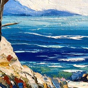 May include: Impasto oil painting of a coastal scene. The artwork depicts a vibrant blue ocean with white-capped waves, a rocky shoreline, and a tree. The sky is a light blue. The painting uses thick brushstrokes to create texture and depth.