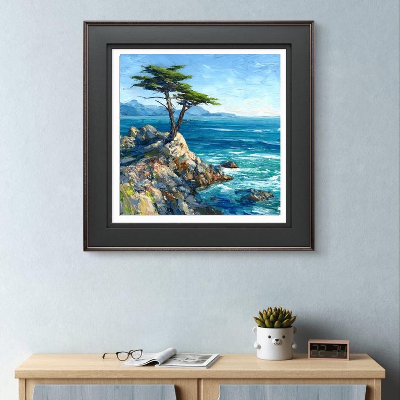 May include: A framed landscape painting depicts a lone tree on a rocky cliff overlooking a vibrant blue ocean. The artwork features a bright blue sky and a dark brown frame. The painting's style is impressionistic, with visible brushstrokes.