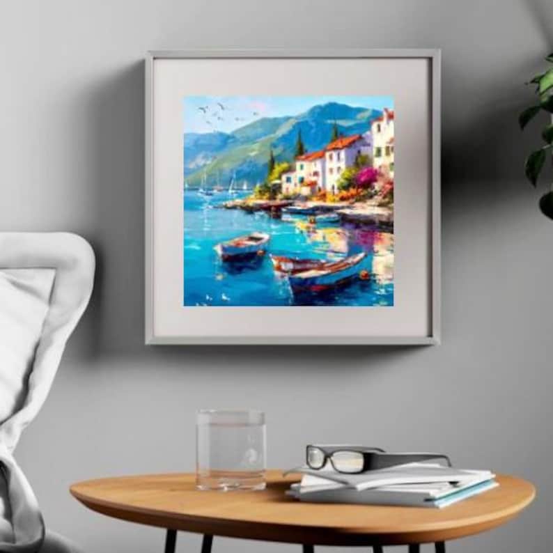 May include: Framed art print of a coastal scene with boats, buildings, and mountains. The artwork features a vibrant color palette of blues, greens, and whites, with a focus on the water and the architecture. The painting is displayed on a gray wall.
