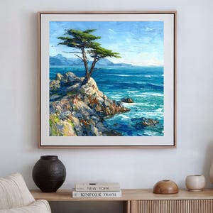 May include: Oil painting of a coastal landscape featuring a tree on a rocky cliff overlooking the ocean. The artwork has a textured appearance with shades of blue, green, and white, framed in a light wood frame.