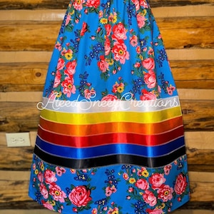 Peut inclure: Une jupe florale bleue avec une bordure de ruban color&eacute;. La jupe a une bordure de ruban blanc, jaune, orange, rouge, bleu et noir. La jupe est faite d'un tissu doux et confortable et est parfaite pour toutes les occasions.