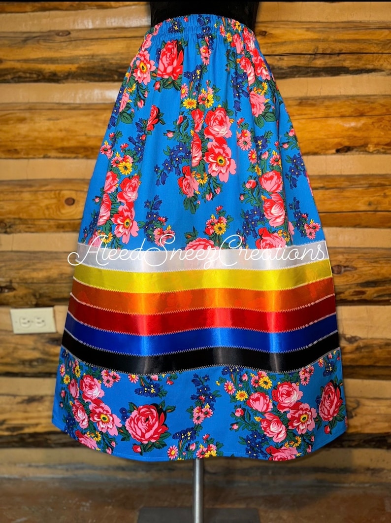 Peut inclure: Une jupe florale bleue avec une bordure de ruban color&eacute;. La jupe a une bordure de ruban blanc, jaune, orange, rouge, bleu et noir. La jupe est faite d'un tissu doux et confortable et est parfaite pour toutes les occasions.