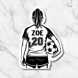 May include: Black and white sticker of a soccer player from the back, holding a soccer ball. The player wears a jersey with "ZOE" and the number "20" on the back. The player has a ponytail.