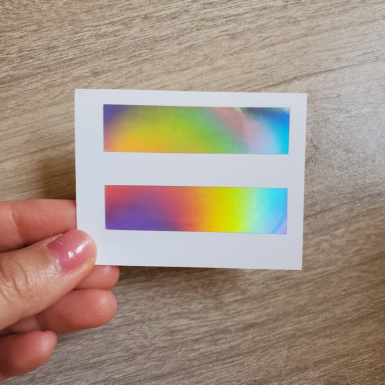 May include: Two iridescent rectangular stickers on a white background. The top sticker is a gradient of yellow, green, and blue. The bottom sticker is a gradient of purple, orange, and blue.