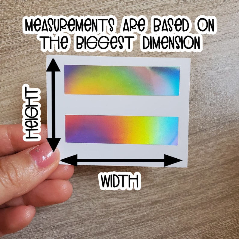 May include: White sticker with two iridescent holographic rectangles. The sticker has the text "Measurements are based on the biggest dimension" at the top and "Height" and "Width" written vertically on the left and horizontally at the bottom.