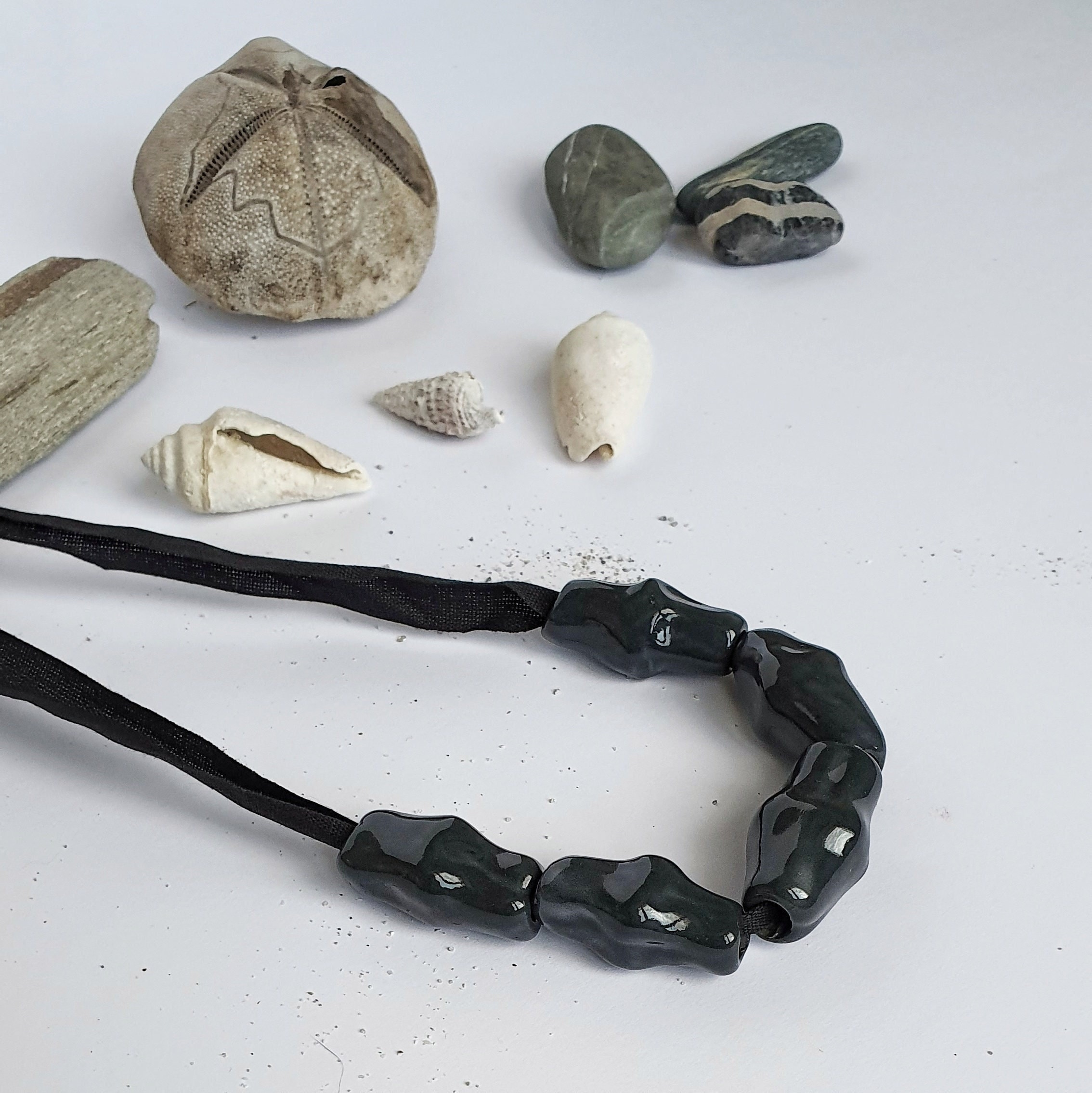 Necklace with black porcelain beads in the shape of a shell adjustable with a pearl.
