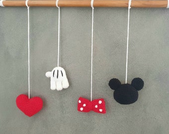 May include: A set of four crocheted hanging ornaments featuring a red heart, a white glove, a red bow with white polka dots, and a black Mickey Mouse head.