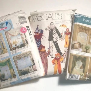 May include: Three McCall's sewing pattern envelopes. One features a clown design, another shows window treatments, and the third displays home decor window treatments. The patterns are for home sewing projects.