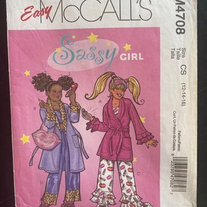 May include: A sewing pattern for a girl's robe and pajamas. The pattern is called "Sassy Girl" and is for sizes 12-14-16. The pattern includes a pink robe with a tie belt and a pair of pajamas with a lipstick print.