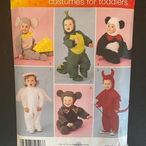 Puede incluir: Patrón de costura Simplicity número 2506 para disfraces de niños pequeños. El patrón incluye cinco disfraces: un ratón, un dinosaurio, un panda, un ángel y un diablo. El patrón es para las tallas 1/2, 1, 2, 3 y 4.