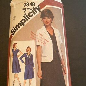 May include: Simplicity sewing pattern number 9848 for a dress and jacket. The pattern is for size 14 miss and costs $2.50. The pattern shows a model wearing a white jacket with a black skirt and a white blouse. The pattern also shows two other dresses, one blue and one white.