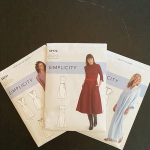 Puede incluir: Tres patrones de costura Simplicity para vestidos. Los patrones son para las tallas AA, XS-S y M-L. Los patrones son para un vestido rojo, un vestido blanco y un vestido azul claro.
