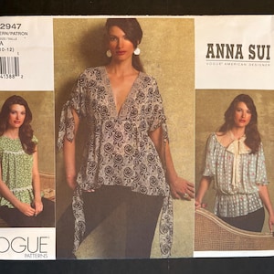 May include: Vogue Patterns sewing pattern V2947 by Anna Sui. The pattern features three different blouse designs. The front of the pattern shows a woman wearing a floral print top with a deep V-neck. The pattern includes sizes 6-8-10-12.