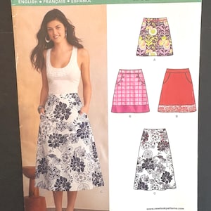以下が含まれることがあります： 白いタンクトップと花柄のロングスカートを着た女性が写っている、New Lookのソーイングパターン。さまざまなスタイルのスカートのデザインが含まれています。パターンサイズはU.S. 10-22で、フランスサイズ38-50、ヨーロッパサイズ36-48に相当します。